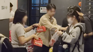 강안교육 1층 엘리베이터 앞에서 CJ프레시웨이 직원 두 명이 재원생에게 팀빗 박스와 포장 음료를 나눠주는 장면