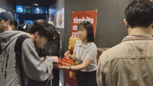 9월 모의평가 전날 강안교육 1층에서 CJ프레시웨이 직원이 하원하는 재원생에게 팀홀튼 팀빗 박스를 건네는 모습